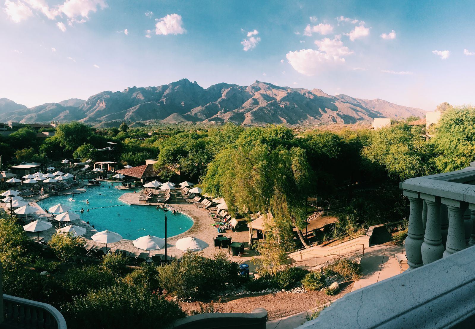 A resort-style swimming pool with desert mountains behind